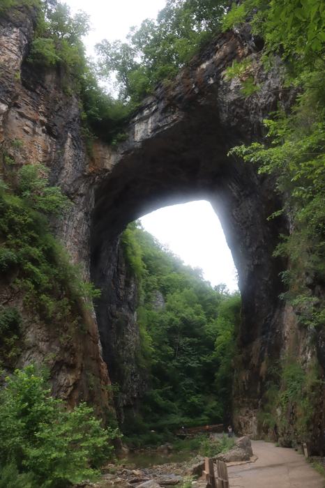 A natural bridge made of stone connects two rock faces.