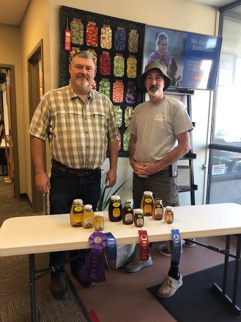 local Extension Director with local honey producer showing fair ribbons