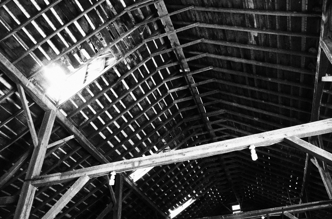 The roof of a barn with small amounts of light coming through.