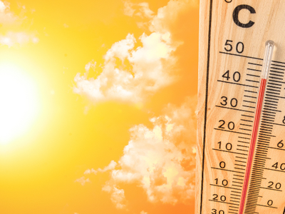 Thermometer reading about 40°C beside bright sun and orange sky