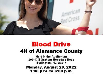 Donor waves to camera beside Red Cross truck.