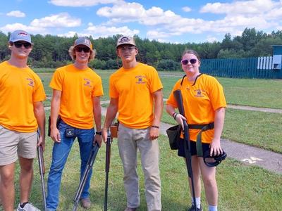 Four youths at a gun range holding their firearms.