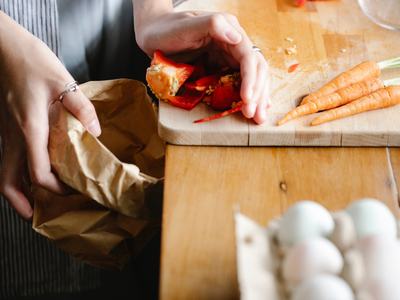 person scraping food scraps into trash can