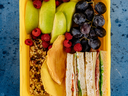 sandwich, fruit and granola in a lunch container
