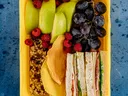 sandwich, fruit and granola in a lunch container