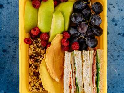 sandwich, fruit and granola in a lunch container