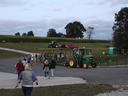 Families get ready to take a ride around Johnny Wilson Farm during fall 2021. There's a pumpkin patch, corn maze and tractors parked outside.