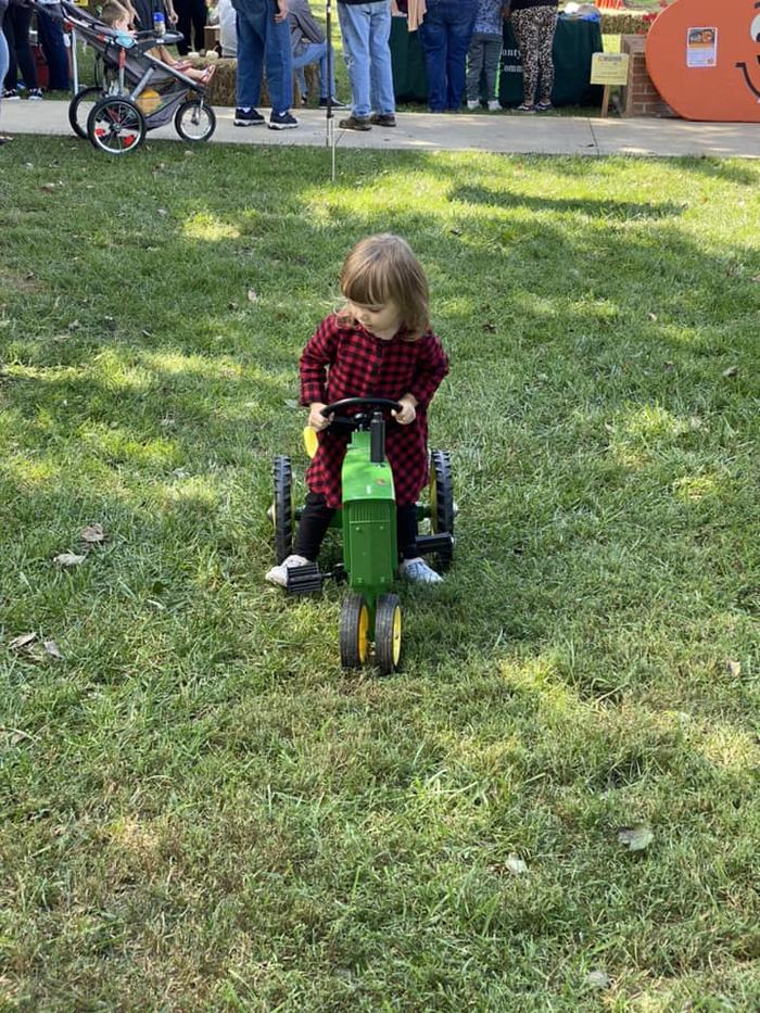 child on toy tractor