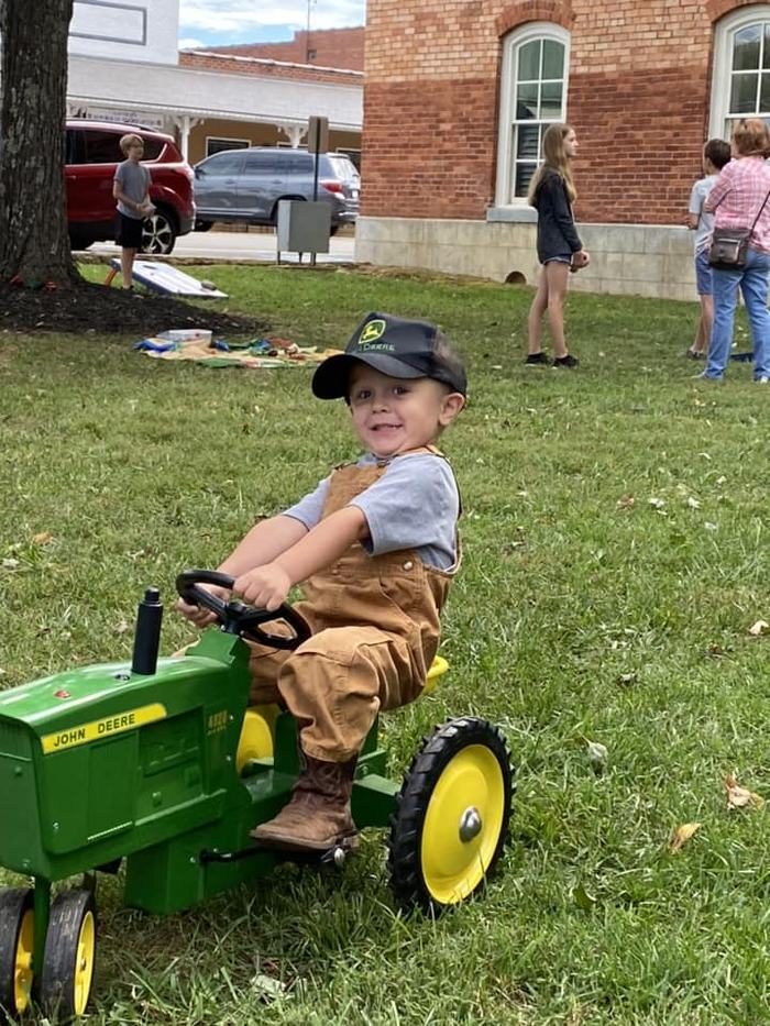 child on toy tractor