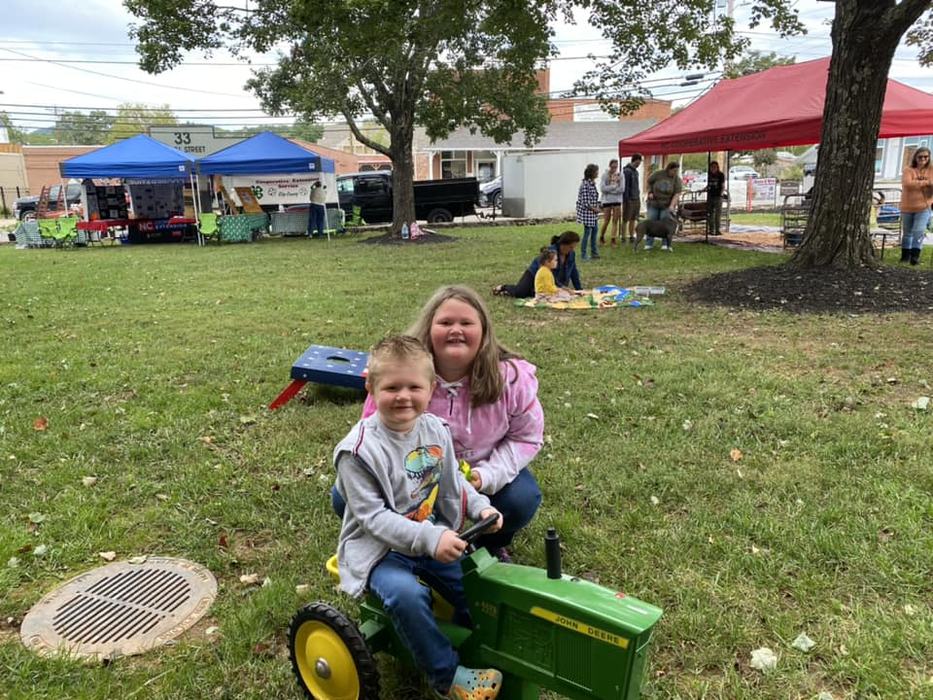child on small toy tractor