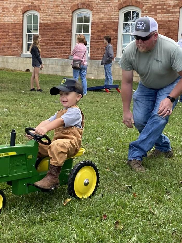 young child sitting on a toy tractor