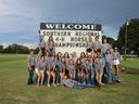 Group of youth in gray shirts before sign: "WELCOME SOUTHERN REGIONAL 4‑H HORSE CHAMPIONSHIP"