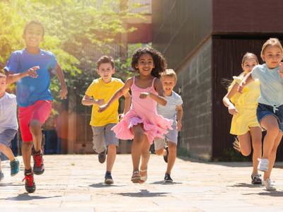 Team of positive kids running in race and laughing outdoors