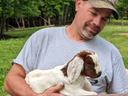 farmer holding baby goat