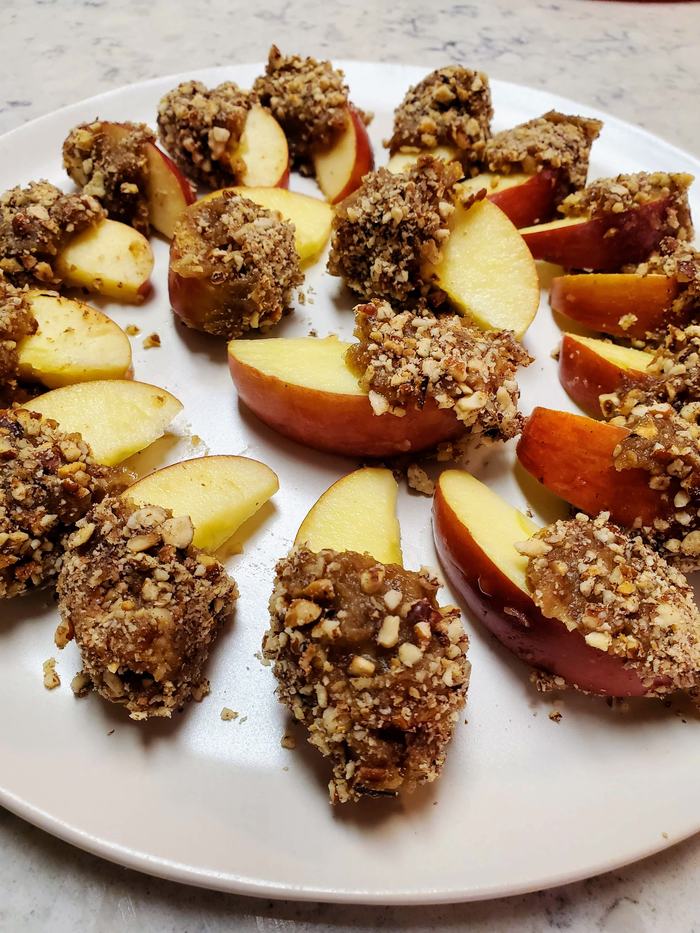 Apple slices covered with date spread and pecans.