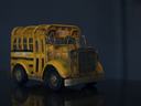 Yellow toy school bus model on reflective surface against dark background