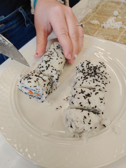 A person slices sushi.