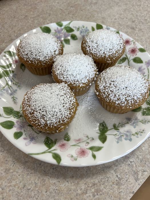 Pumpkin bread muffins that have been covered in powered sugar.
