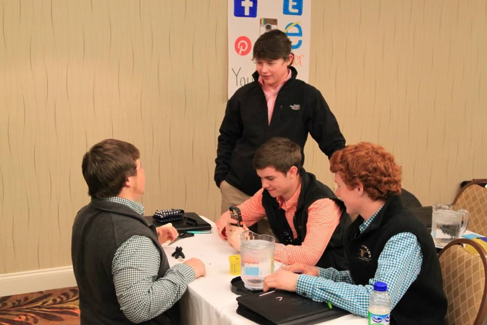 A group of youths sit at a table.