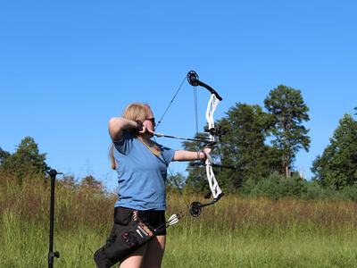 A woman pulls a bow tought.