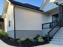 A white house with mulched landscape