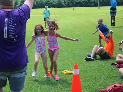 color game participants race toward the finish line as the other campers go wild cheering them on