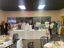 People standing behind a table with posters and sign: Pitt County 4H Allstars Club 25th Anniversary
