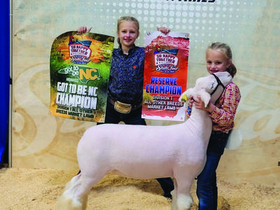 girls showing winning sheep at the fair