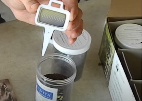 Contents of a Respiration Test Kit including an indicator test paddle and containers for soil. The paddle is yellow which indicates high respiration.