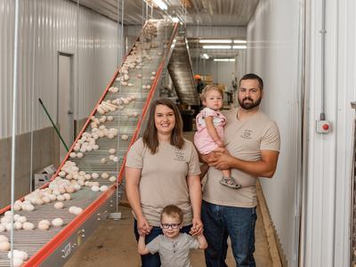 Family standing next to egg conveyer belt