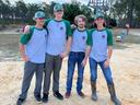 Four people pose together in 4-H shirts.