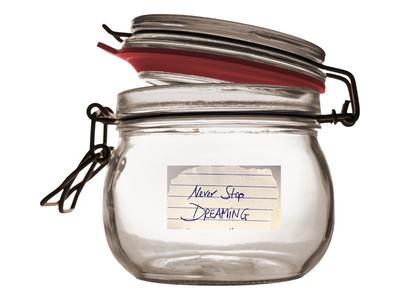 Glass jar with hinged lid holding a note that reads "Never Stop DREAMING."