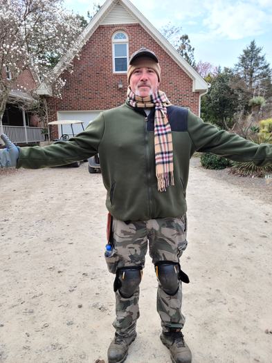 man with arms out in garden