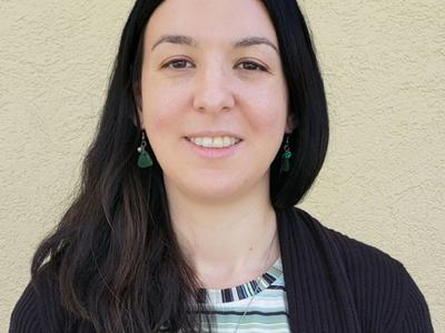 Headshot photo of Paige wearing a striped shirt and black jacket