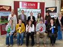 Group of students holding award ribbons in front of NC STATE UNIVERSITY sign