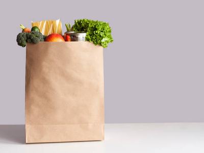 Brown paper bag full of grocery items.