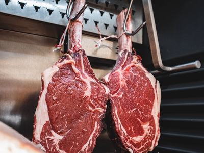 fresh beef steaks cut and hanging on a rack