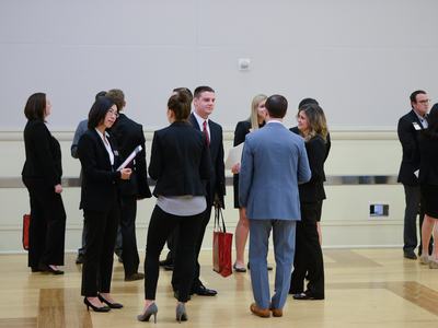 A group of professional dressed people are networking at a business event.