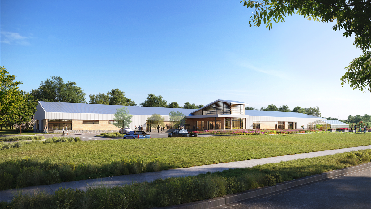 green grass, building with glass entry and metal roof