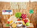Wheat field with fruits, vegetables and cereal on a table; text "YOUR TABLE YOUR FOOD"