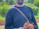 Zac holding carrots from garden
