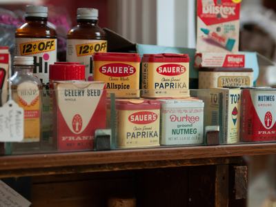 Shelf of vintage spice tins including Sauer's Paprika and Durkee ground Nutmeg