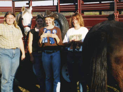4-H members and Lisa Deal pose with their horses and ribbons after a horse show in 2003.