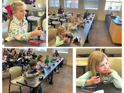 Children in classroom using handheld buzzers at desks during group activity