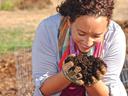 Gardener with soil in hands smiling