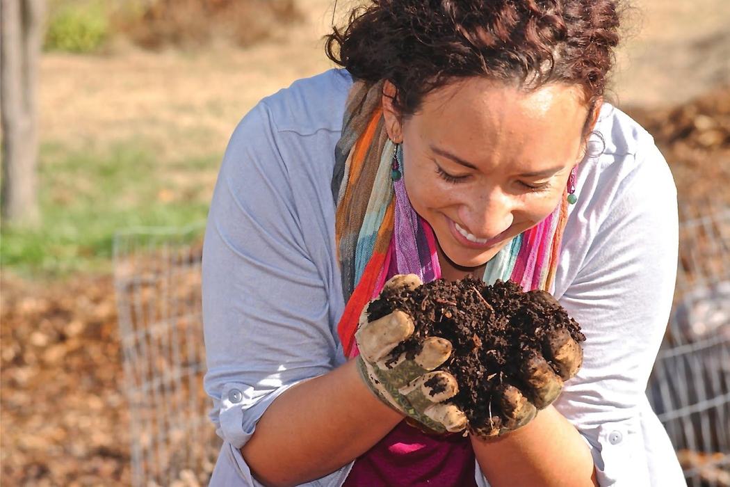 Gardener with soil in hands smiling