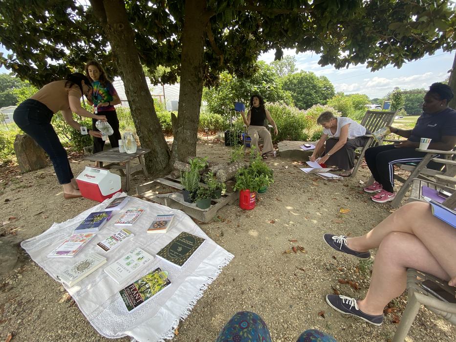 People sitting in the shade with books and water.
