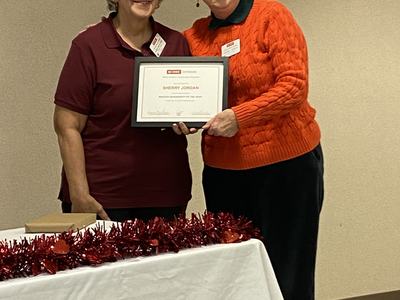 Two women holding framed certificate reading "SHERRY JORDAN" "MASTER GARDENER OF THE YEAR"