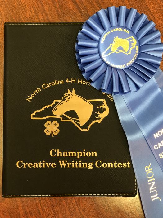Black cover reading "Champion Creative Writing Contest" with blue ribbon "North Carolina 4‑H Horse Program" labeled "Junior"