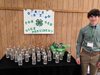 White male teen in green shirt campaigns for district office